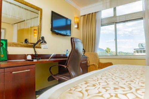 布兰太尔Sunbird Mount Soche的酒店客房带一张床、一张书桌和一面镜子