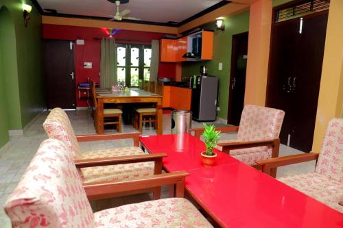 奇旺Hotel Park Treasure的客厅配有红色的桌子和椅子