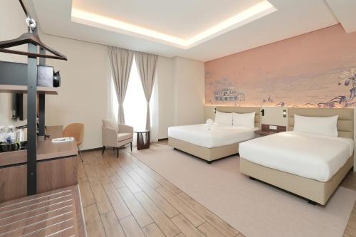 怡保Cititel Express Ipoh的一间酒店客房,设有两张床和电视