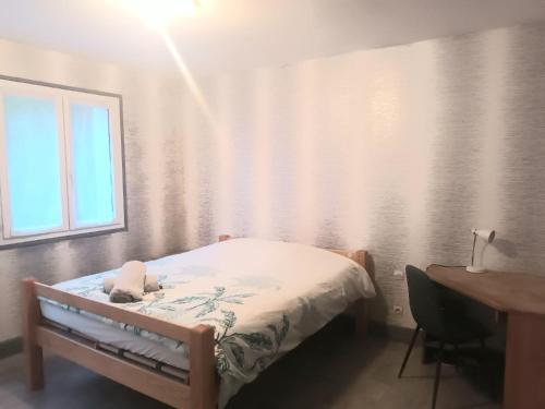 勒阿弗尔La Vallée, spacieuse maison 6 chambres, Le Havre的一间卧室配有一张床、一张书桌和一个窗户。