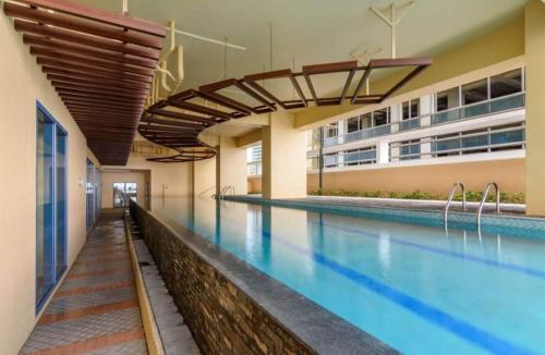 马尼拉Grand Riviera suite Condotel的游泳池,位于带游泳池的建筑内
