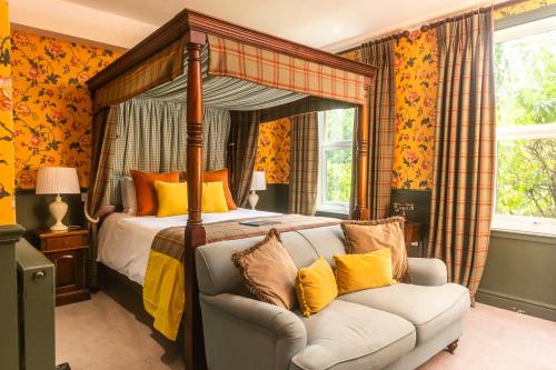 巴斯欧菲尔姿别墅酒店的一间卧室配有天蓬床和沙发