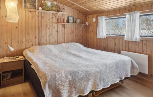 Bogø By3 Bedroom Nice Home In Bog By的木制客房内的一间卧室,配有一张床