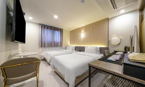 坡州市Paju Geumchon Grache的酒店客房配有两张床和一张书桌