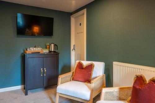 博克斯诺西纹章酒店的客厅配有两把椅子和电视