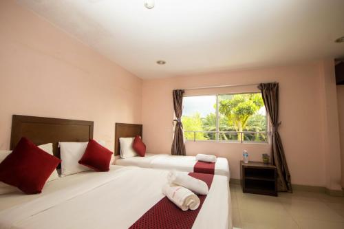 Batang BerjuntaiSun Inns Hotel Bestari Jaya的一间卧室配有两张带红色枕头的床和窗户。