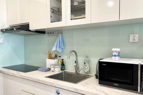 河内Vinhomes Smart City - Căn hộ đẹp, sang trọng tại tòa nhà S1.02的厨房柜台设有水槽和微波炉