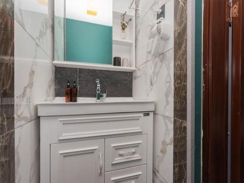 昆明八街安妮公寓 - 距离地铁2号线/穿心鼓楼B出口仅120米的浴室设有白色水槽和镜子