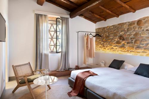 瓦尔的圣卡西亚诺萨尔瓦多妮卡酒店的一间卧室设有一张大床和一张玻璃桌