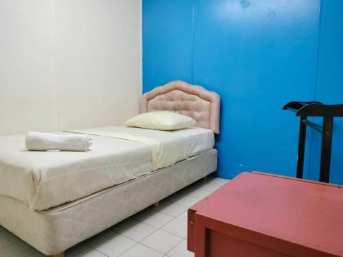 马六甲Grand Heritage Hotel的一间卧室设有一张床和蓝色的墙壁