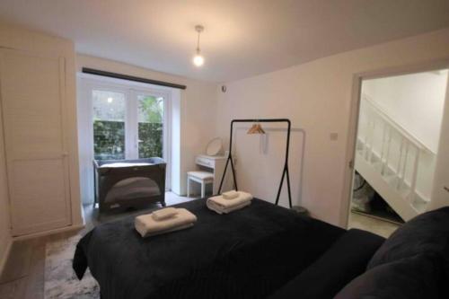 伦敦Apartment - Heart of London!的一间卧室配有一张黑色床和两条毛巾