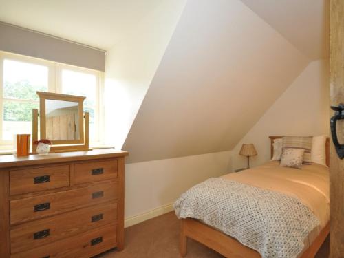 2 Bed in Newthorpe 47031的一间卧室配有一张床和一个带镜子的梳妆台