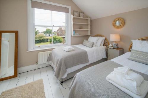 本布里奇Fern Cottage的一间卧室设有两张床和窗户。