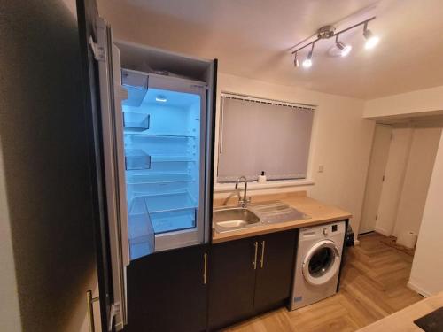 利物浦Anfield - Stylish four-bedroom Victorian house的厨房配有水槽和洗衣机