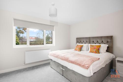 奥平顿OnSiteStays New Large modern 4 bed, Parking, Wifi, 2 x Bathroom的一间卧室设有一张大床和窗户
