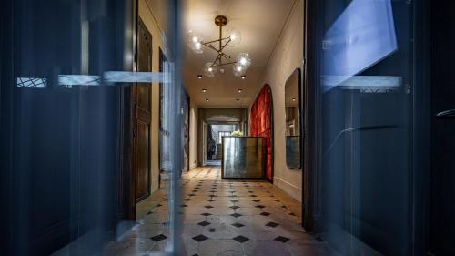 南希Hotel De Guise Nancy Vieille Ville的走廊设有蓝色的墙壁和吊灯