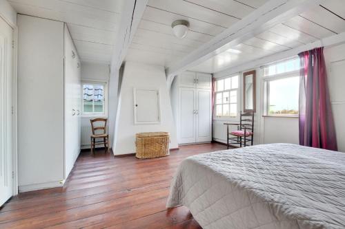 ZaandijkPakhuys bij de Zaanse Schans的卧室配有一张床和一张桌子及椅子