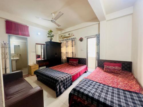 达卡Appayan Guest House Baridhara (Bhagyakula Building)的一间卧室配有两张床、一把椅子和镜子