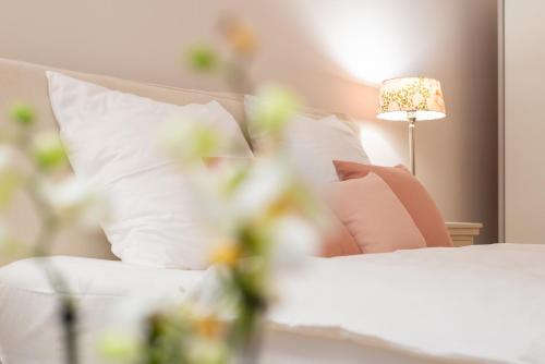 达姆施塔特Livingroom Mathildenhöhe的一间卧室配有带白色枕头和灯的床