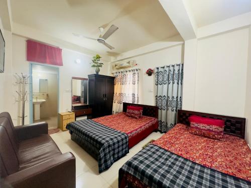 达卡Appayan Guest House Baridhara (Bhagyakula Building)的酒店客房,配有两张床和椅子