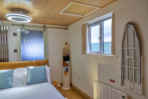 廷塔杰尔Finest Retreats - Treknow Summerhut的一间卧室配有一张床和一个冲浪板
