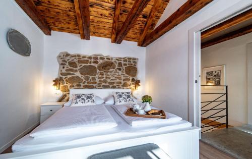 洛帕House Filumena的一间卧室设有一张大床和木制天花板。