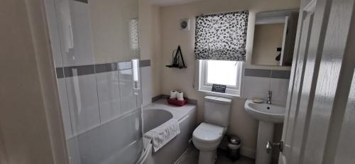 邓弗里斯The Wee Hoose的浴室配有卫生间、浴缸和水槽。
