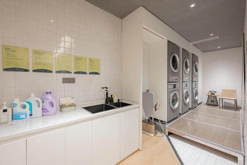 嘉定上海嘉定菊园智慧中心亚朵酒店的白色的厨房配有水槽和洗衣机