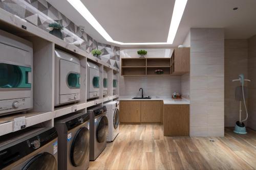 深圳深圳西丽创新谷亚朵酒店的洗衣房配有多台洗衣机和水槽