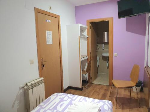 马德里阿贝尔维多利亚诺旅馆的一间带紫色墙壁和一张床的卧室以及一间浴室。