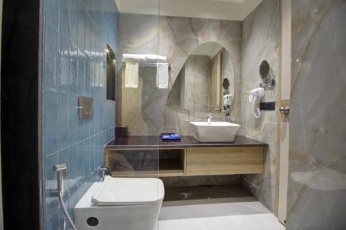FaizābādCygnett Collection K K Hotel的一间带水槽、卫生间和镜子的浴室