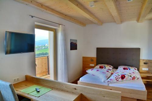马兰扎Hotel Pfeiferhof的一间卧室配有一张床、一张桌子和一个窗户。