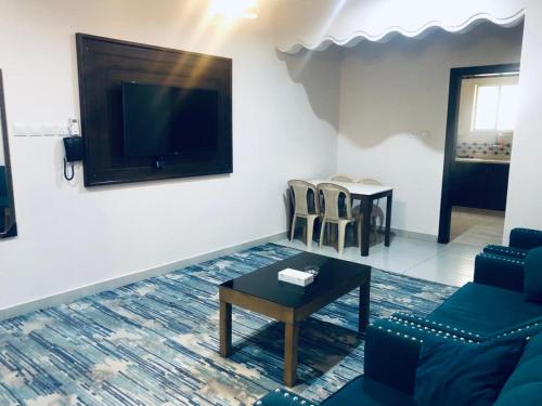 达瓦迪米افضل واحد للوحدات السكنية المخدومة - بست ون的带沙发、桌子和电视的客厅