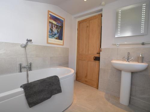 布里德波特3 Bed in Bothenhampton DC160的一间带水槽、浴缸和卫生间的浴室