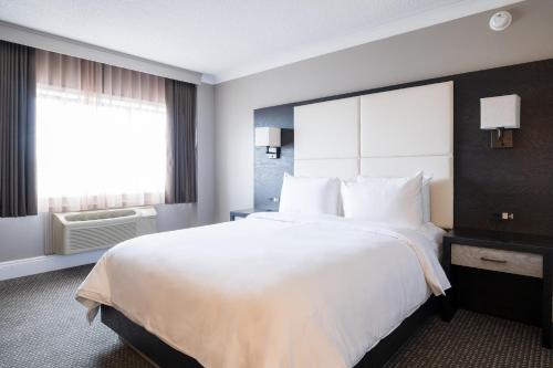 蒙克顿蒙克顿市区皇冠假日酒店的一张大白色床,位于酒店带窗户的房间内