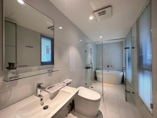 Zhongpu里山下民宿的白色的浴室设有卫生间和水槽。