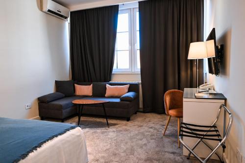 贝尔格莱德勒佩特皮亚弗加尼酒店的酒店客房设有沙发和窗户。