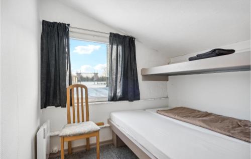 灵克宾Beautiful Apartment In Ringkbing With Wifi的卧室配有床、椅子和窗户。