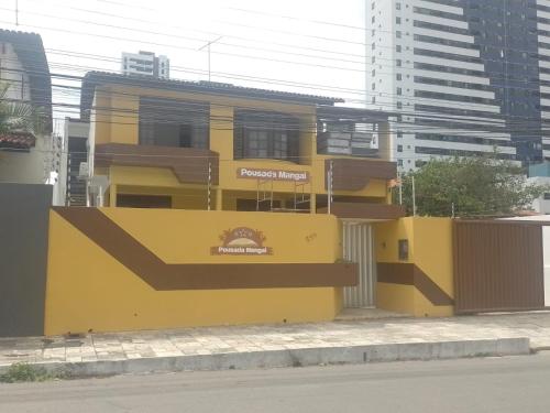 若昂佩索阿Pousada Mangai的街道边的黄色建筑