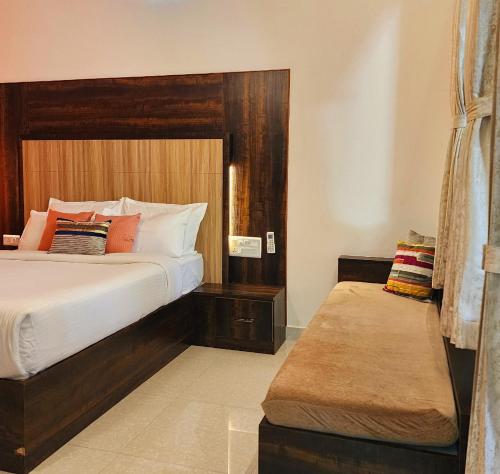 西达普尔Riyavar Luxury Homestay的一间卧室配有一张大床,里面设有长凳