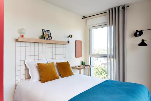 拉贝格Hife Toulouse Labège的一间卧室设有一张床和一个窗口