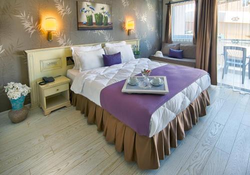 马尔马里斯浪漫海滩酒店的酒店客房设有一张大床,上面有托盘