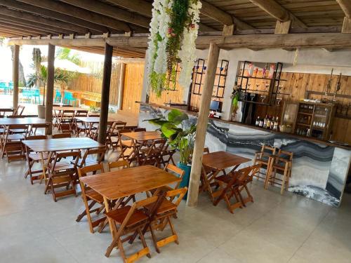 阿拉亚尔达茹达Santorini Beach Hotel的餐厅设有木桌和木椅
