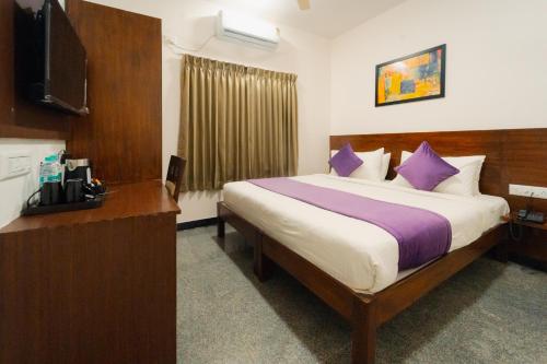 班加罗尔耶拉汉卡霍波尔斯站住宿加早餐旅馆的酒店客房配有一张带紫色枕头的大床