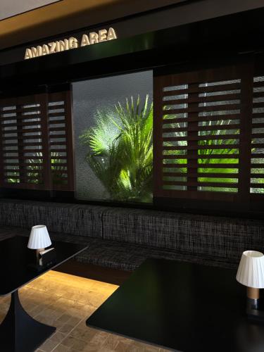 大理大理安汋海景酒店的一间设有大窗户的房间,墙上挂着植物