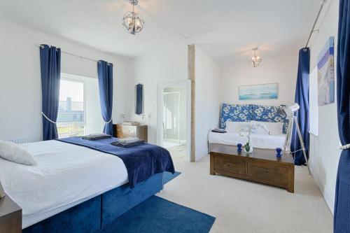 利斯坎诺Holland House No1的蓝色和白色的卧室设有床和窗户