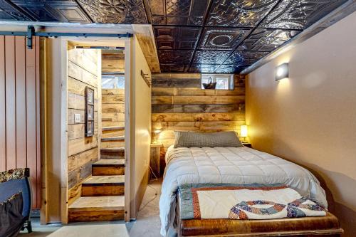 CarrabassettSugarloaf Valley Escape的一间卧室设有一张床和木墙