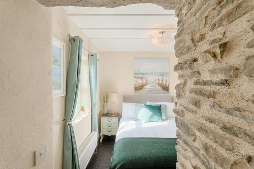 利斯坎诺The Boathouse On The Atlantic Sea的一间卧室设有一张床和石墙