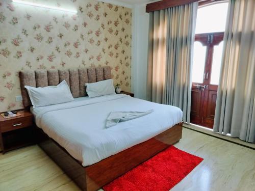 新德里Hotel Soft Petal Residency - Delhi Airport的卧室配有一张白色大床和红色地毯