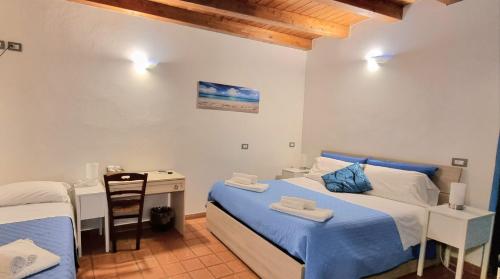 锡拉库扎特雷阿尔奇旅馆的一间小卧室,配有两张床和一张书桌